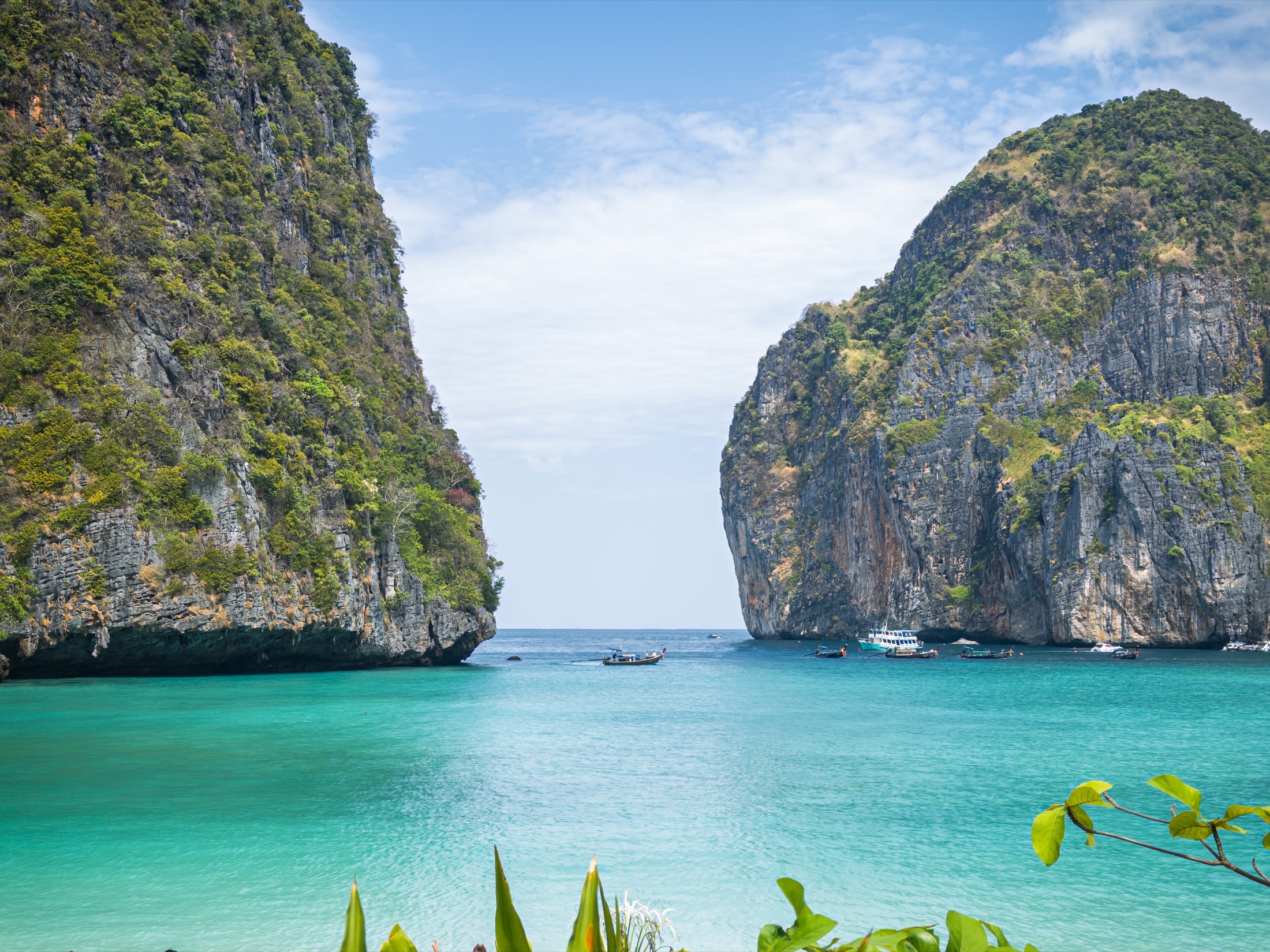 Maya Bay on Koh Phi Phi Leh with longtail boats near limestone cliffs